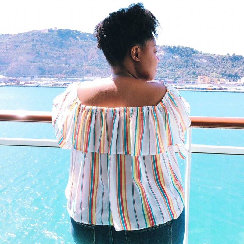 Black woman on balcony overlooking sea